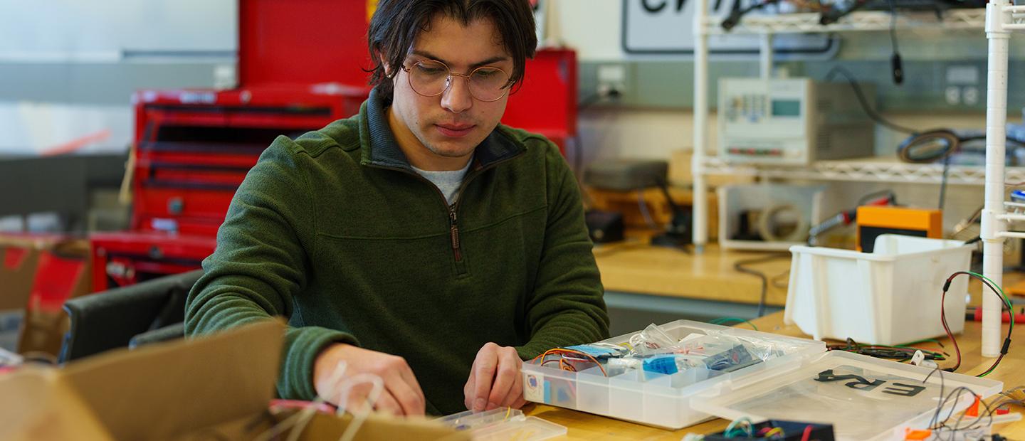 A student working in a lab with wires